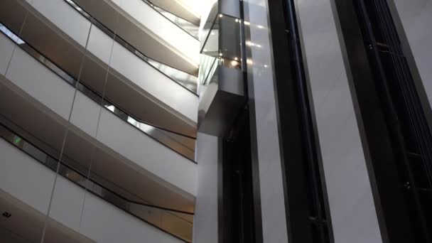 Varias plantas de gran centro de negocios contemporáneo con oficinas de espacio abierto, ventanas, balcones y ascensor entre ellos - Metraje, vídeo