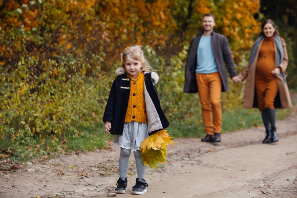 père fille et mère enceinte marchant par parc d'automne jeune famille heureuse - Photo, image