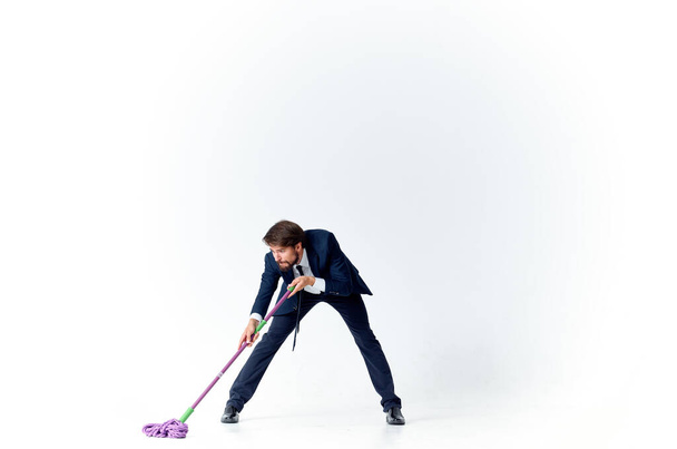 business man in a suit with a mop in his hands providing services cleaning floors - Photo, Image