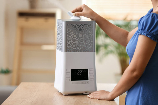 Mujer con humidificador de aire moderno en casa - Foto, Imagen