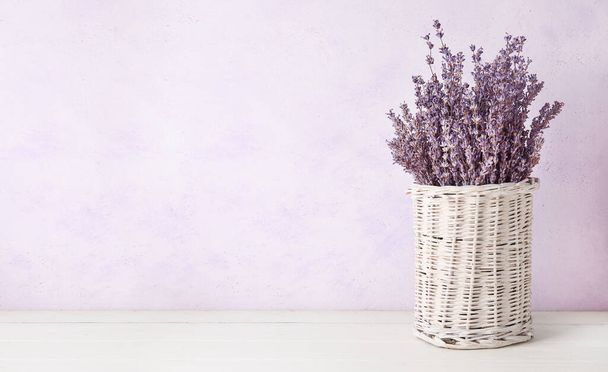 Wicker vase with beautiful lavender flowers on white background - Photo, Image