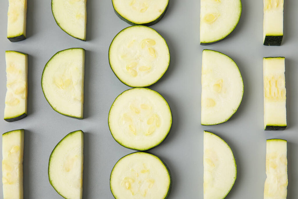 Slices of fresh zucchini squash on grey background - Φωτογραφία, εικόνα