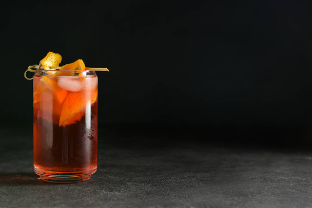 Glass of tasty Negroni cocktail on dark background - Фото, зображення