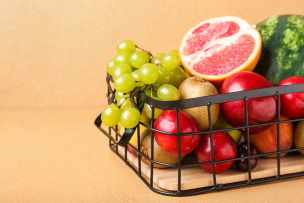 Καλάθι με φρέσκα φρούτα στο φόντο χρώμα, closeup - Φωτογραφία, εικόνα