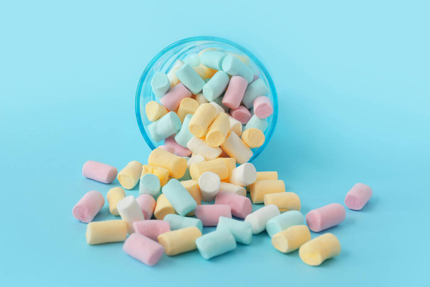 Glass with marshmallows on blue background - Foto, imagen