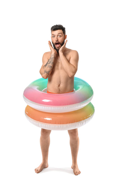 Funny young man with inflatable rings on white background - Photo, Image