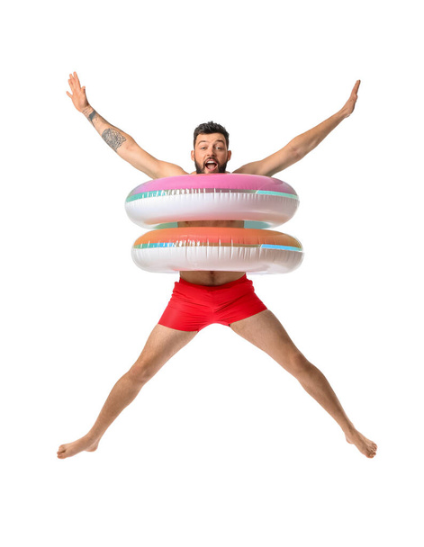 Jumping junger Mann mit aufblasbaren Ringen auf weißem Hintergrund - Foto, Bild