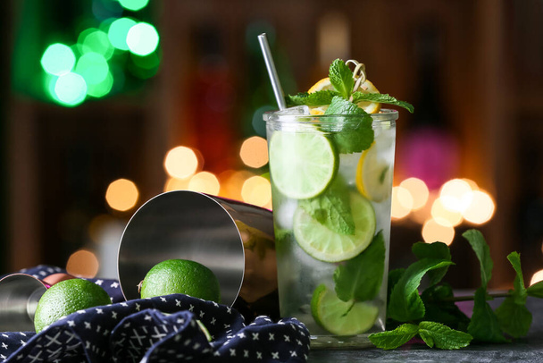 Glass of cold mojito on table against blurred lights - Foto, Imagen