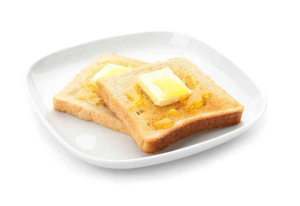 Тарілка зі смачним підсмаженим хлібом з медом та маслом на білому тлі
 - Фото, зображення
