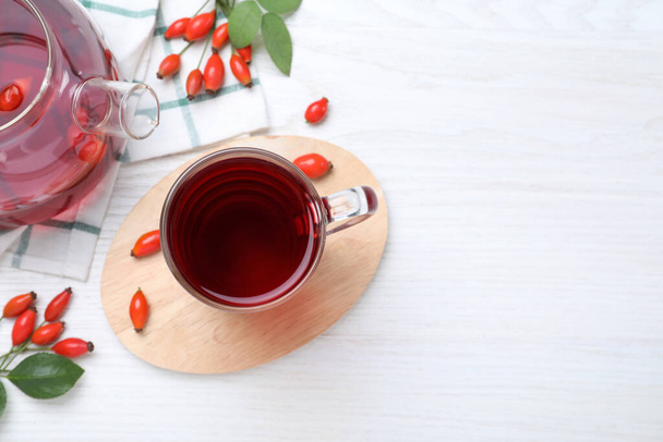 Flat lay composition with aromatic rose hip tea on white wooden table. Space for text - Foto, Bild