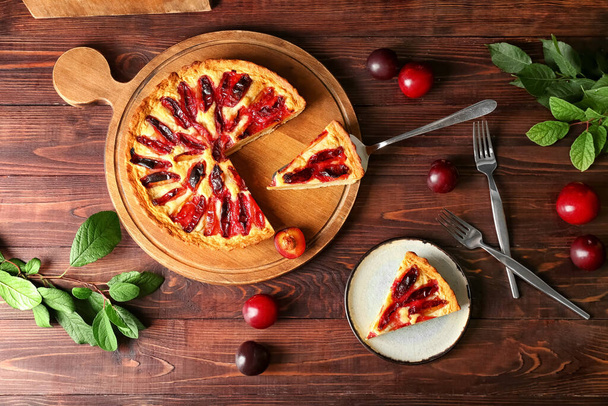 Composition with tasty plum pie on wooden background - Фото, изображение