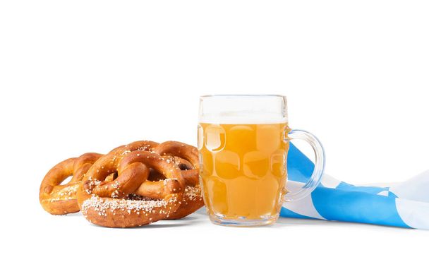 Кружка свежего пива и крендельки на белом фоне. Праздник Октоберфеста - Фото, изображение