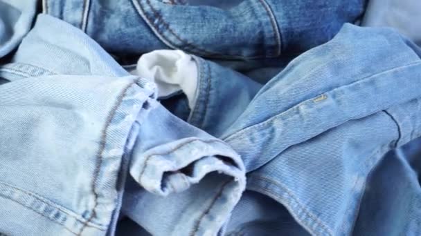 Close-up van gevouwen blauwe jeans draaiend op een roterende achtergrond - Video