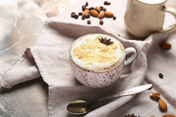 Ένα φλιτζάνι νόστιμο latte αμύγδαλο σε grunge φόντο - Φωτογραφία, εικόνα