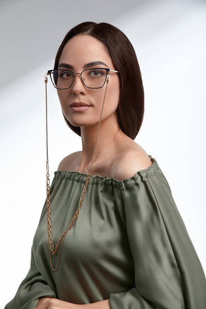 Stylish young brunette in a green dress and glasses, magazine cover, fashion industry, successful business woman. - Fotoğraf, Görsel