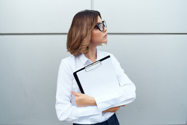 жінка-менеджер у білій сорочці документи на відкритому повітрі
 - Фото, зображення