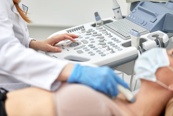 Frau bekommt Ultraschall einer Schilddrüse vom Arzt - Foto, Bild
