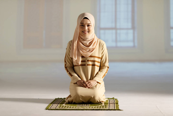 Portrait d'une jeune et belle musulmane en robe de hijab assise dans la mosquée. - Photo, image