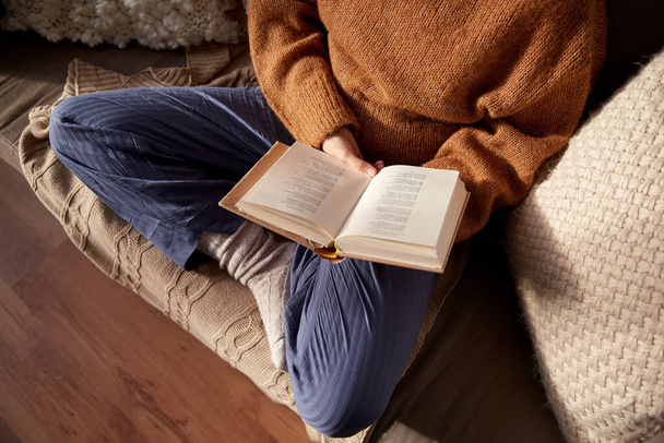 woman in warm sweater reading book at home - Fotoğraf, Görsel