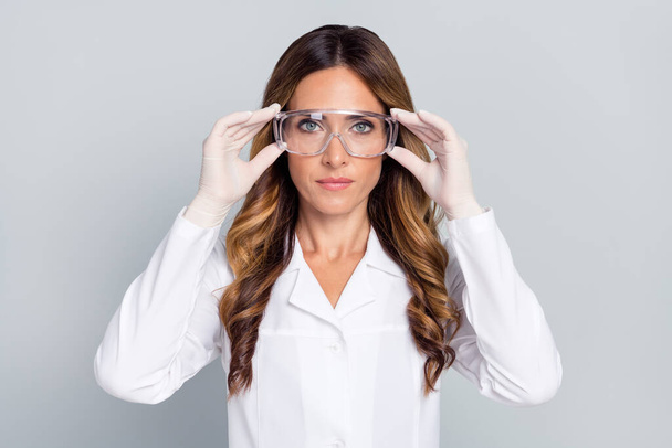 Portrait of attractive wavy-haired woman doc touching specs lab research isolated over grey pastel color background - Фото, изображение
