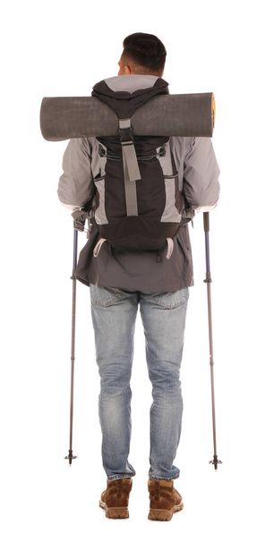 Male hiker with backpack and trekking poles on white background, back view - 写真・画像