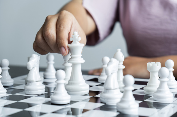 Vrouw schaken en denken strategie plan over crash omver te werpen het tegenovergestelde team en ontwikkeling te analyseren voor succesvol. - Foto, afbeelding