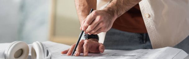 обрізаний вид на малюнок архітектора на планці з олівцем біля розмитої паперової чашки, банер
 - Фото, зображення
