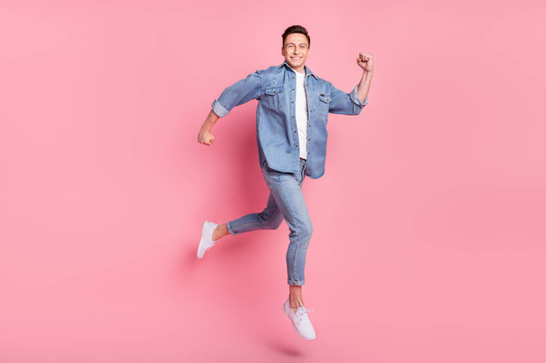 Full size photo of young smiling handsome guy running in air traveling summer vacation isolated on pink color background - 写真・画像