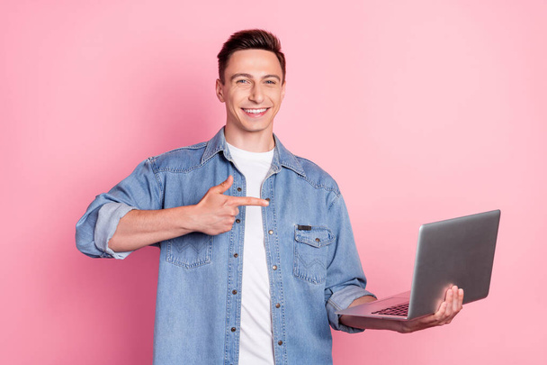 Photo of positive young attractive male businessman point finger laptop advertisement isolated on pink color background - Photo, Image