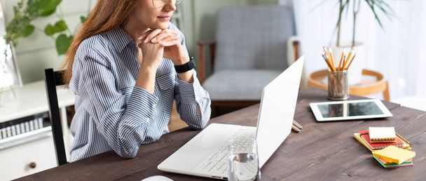 Young woman working with a laptop. Female freelancer connecting to internet at home. Blogger writing new article. - Φωτογραφία, εικόνα