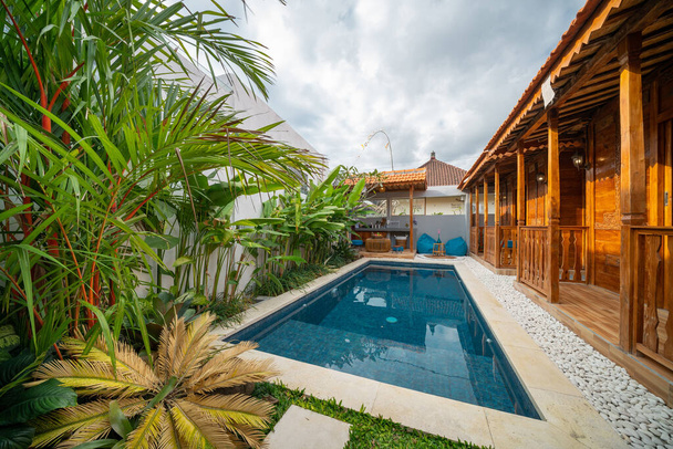 Javanese traditional houses or joglo house. Wooden villas in traditional Indonesian style. Perfect holiday place with pool. Evening concept - Photo, Image