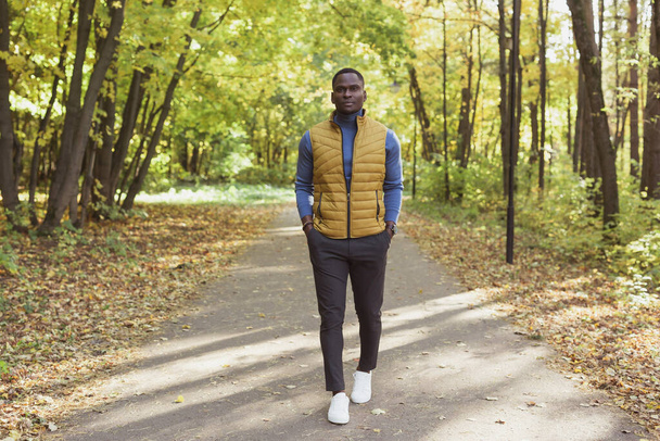 Afrikkalainen amerikkalainen opiskelija kävelee puistossa syksyllä - Valokuva, kuva