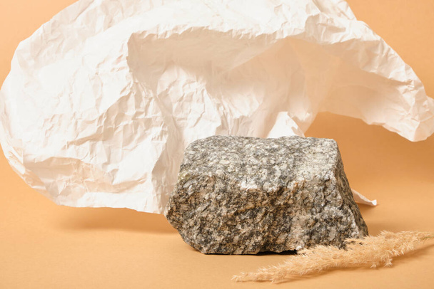 dry grass, crumpled white paper and natural stone on a beige background, background for the presentation of your organic product mock up copy space - Foto, imagen