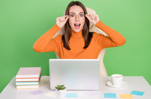 Portrait of lovely trendy cheerful amazed girl agent broker working remotely touching specs reaction isolated over bright green color background - Foto, Imagen