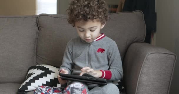 A small boy plays a game on a tablet. Third of four clips. - Filmati, video