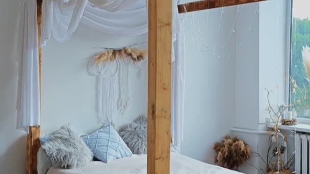 Large boho bed with wooden awning, white canopies and soft pillows. High quality FullHD footage - Footage, Video