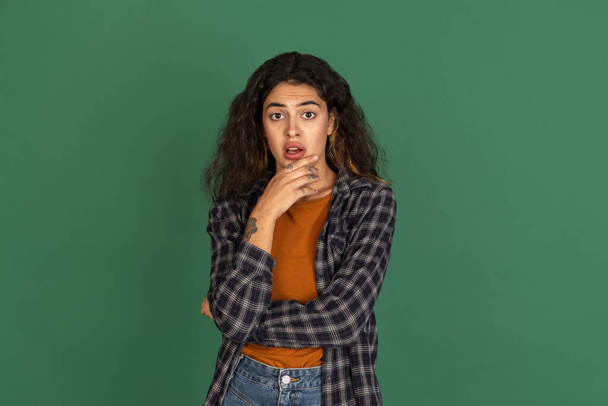 Traditional portrait of Latino beautiful girl isolated on green, vintage color studio background. Concept of human emotions, facial expression, natural beauty, diversity - Foto, imagen