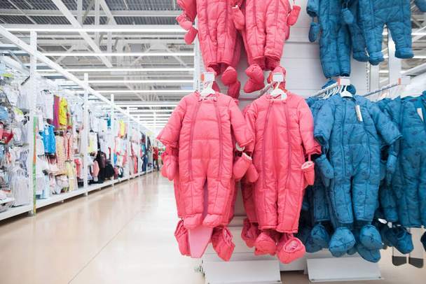 Bemutatók és polcok őszi overallokkal a gyermekruhaboltban - Fotó, kép