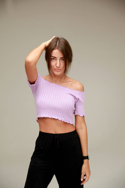 Portrait of   beautiful slender model in black trousers and   purple top.  - Photo, Image