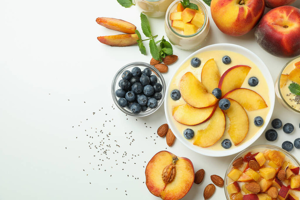 Concept of healthy food with peach yogurt and ingredients on white background - 写真・画像