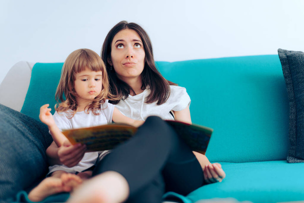 Tired Mother Reading to Her Daughter a Story at Home - Foto, imagen