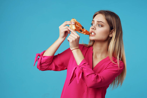 γυναίκα με ροζ πουκάμισο με πίτσα στα χέρια της πρόχειρο φαγητό από κοντά - Φωτογραφία, εικόνα