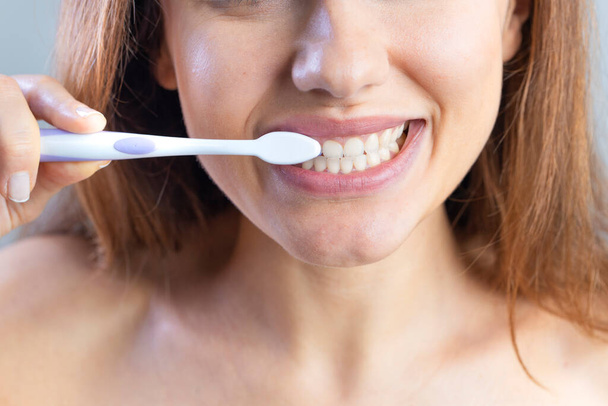Close up of toothbrush in front of woman. Oral and dental health concept. - Foto, Imagem