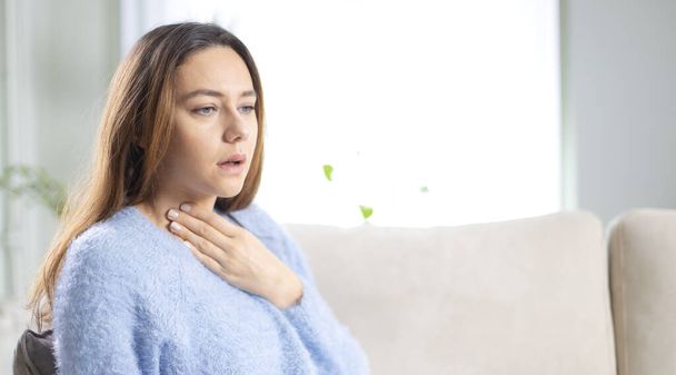 Young woman touching painful neck, sore throat for flu, cold and infection - Foto, imagen