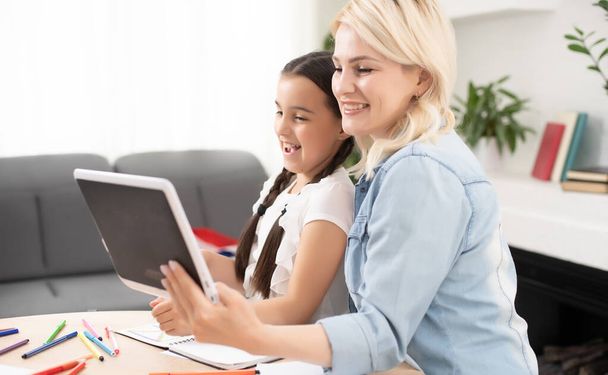 Mother and daughter websurfing on internet with tablet - Φωτογραφία, εικόνα