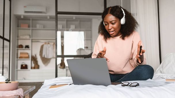 Black Freelancer dame maken van video bellen op laptop in de slaapkamer - Foto, afbeelding