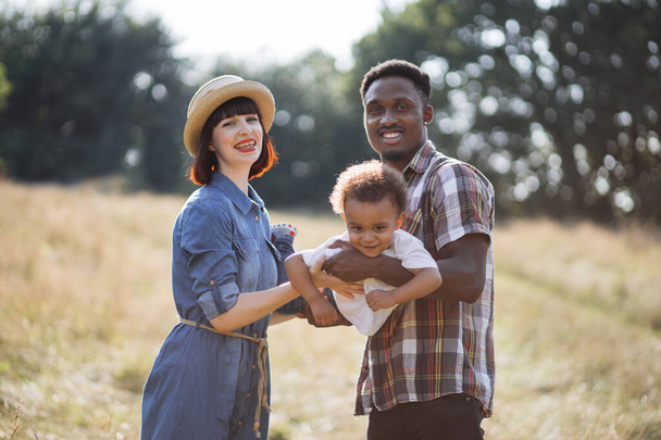 Multiracial parents having fun with little son on nature - Photo, image