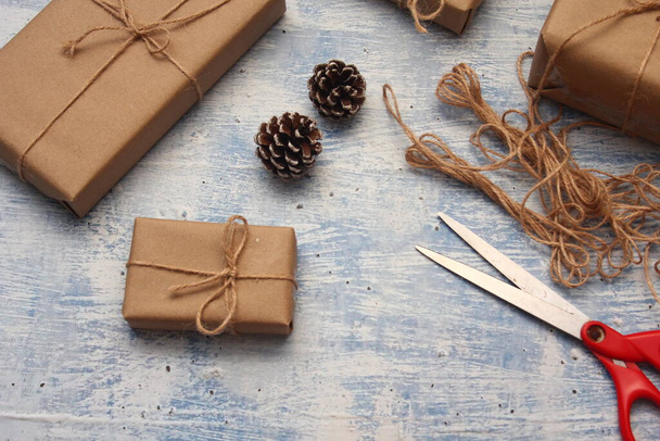 gift wrapping from Kraft paper wrapped with twine, the concept of handmade, light blue tabletop. - 写真・画像