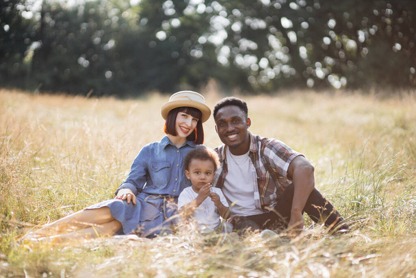 Portrait of happy multiracial family having picnic on nature - Фото, зображення