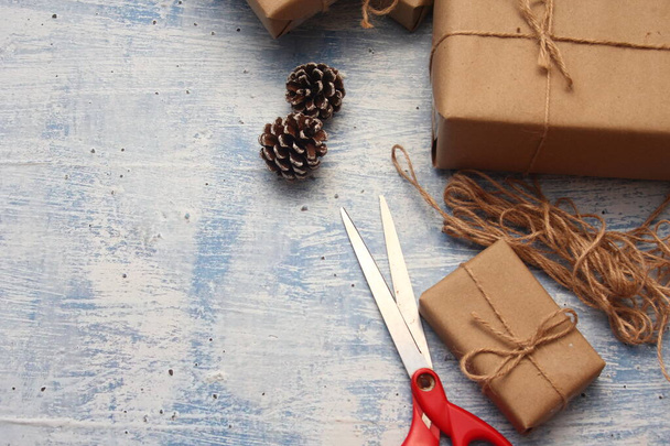 İplikle sarılmış Kraft kağıdından hediye paketi, el yapımı konsept, açık mavi masa üstü. - Fotoğraf, Görsel